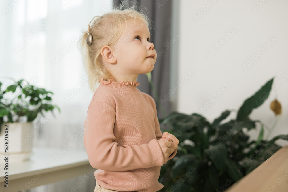 Deaf child girl with cochlear implant studying to hear sounds copy space - recovery after cochlear Implant surgery and rehabilitation concept Deaf child girl with cochlear implant studying to hear sounds copy space - recovery after cochlear Implant surgery and rehabilitation concept