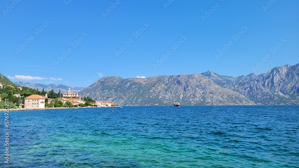 Crystal clear water with mountains in the background in Kotor Bay, Montenegro