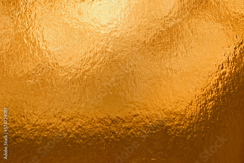  Gold background, texture. Background of gold foil with light reflections. © A_sm