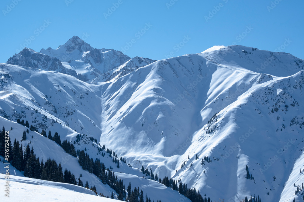 View of Nursultan Peak from a forest pass in winter near Almaty