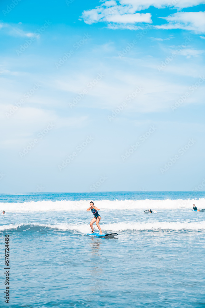 The man is surfing. A novice surfer on the waves in the ocean off the coast of Asia on the island of Bali in Indonesia.