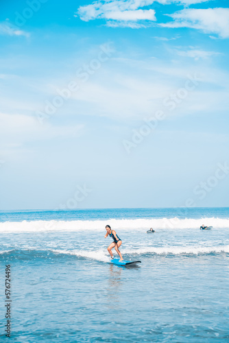 The man is surfing. A novice surfer on the waves in the ocean off the coast of Asia on the island of Bali in Indonesia. © algrigo