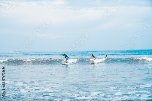 The man is surfing. A novice surfer on the waves in the ocean off the coast of Asia on the island of Bali in Indonesia. © algrigo