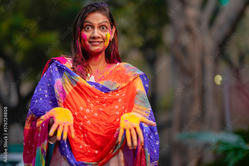 indian young girl showing colourful palm and celebrating holi