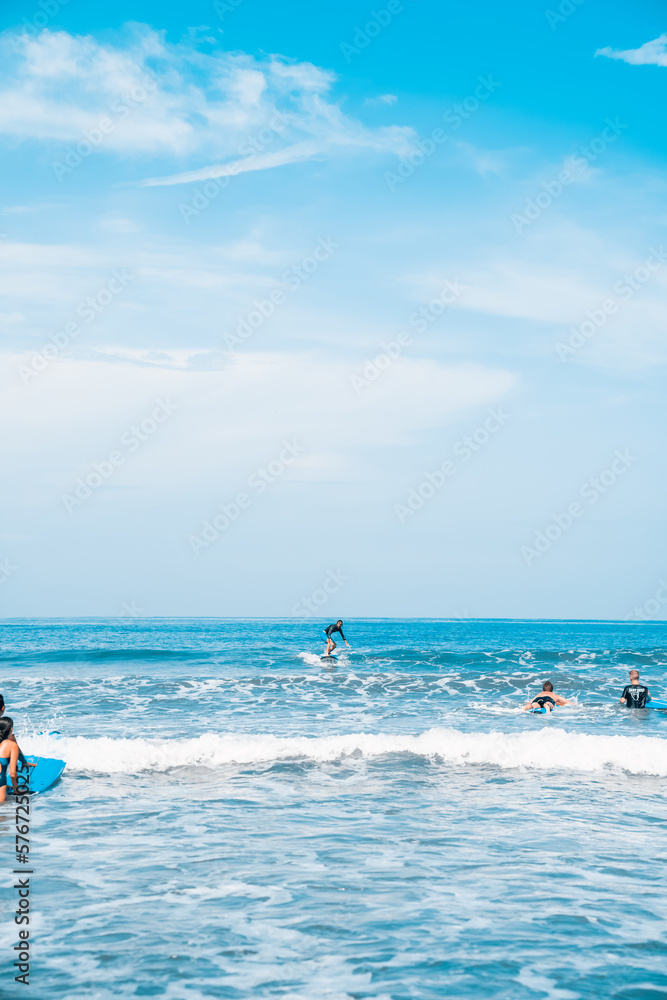 The man is surfing. A novice surfer on the waves in the ocean off the coast of Asia on the island of Bali in Indonesia.