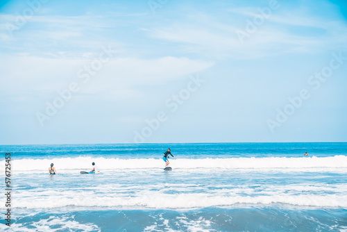 The man is surfing. A novice surfer on the waves in the ocean off the coast of Asia on the island of Bali in Indonesia.