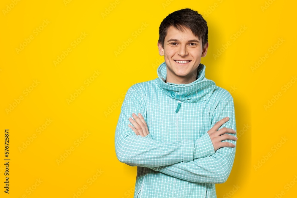 Obraz premium Smiling young man posing with hands crossed