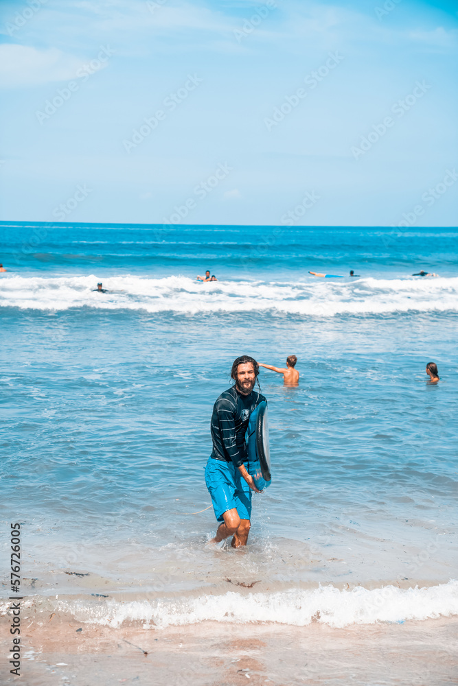 The man is surfing. A surfer on the waves in the ocean off the coast of Asia on the island of Bali in Indonesia. Sports and extreme. Beauty and health. Fashion and beach style. The man is surfing. A surfer on the waves in the ocean off the coast of Asia on the island of Bali in Indonesia. Sports and extreme. Beauty and health. Fashion and beach style.