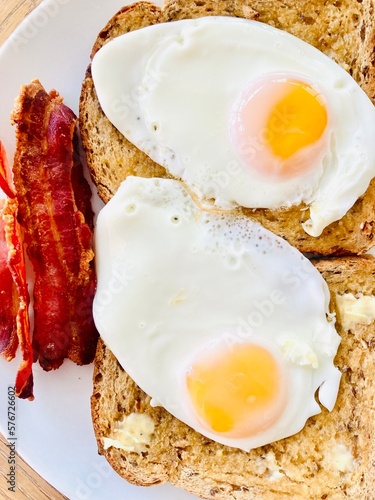 Breakfast with fried eggs, crispy streaky bacon on wholemeal toast