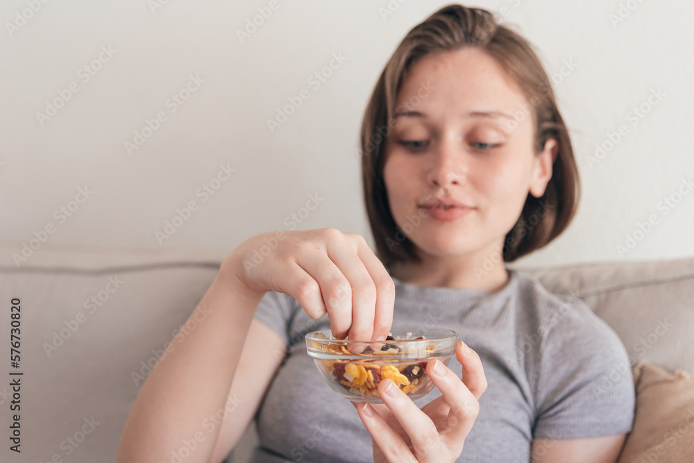Charming woman eating tasty snack on sofa Charming woman eating tasty snack on sofa