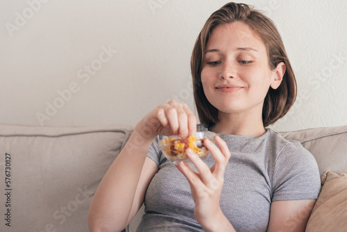 Charming woman eating tasty snack on sofa photo