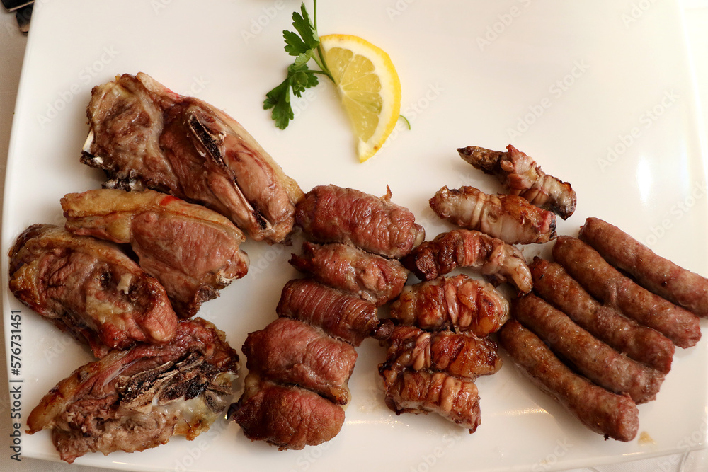 Mixed roast meat. Lamb, gnummareddi or torcinelli, rolls based on lamb offal, sausage and the famous bombette martinesi, meat rolls stuffed with cheese. Italian food Mixed roast meat. Lamb, gnummareddi or torcinelli, rolls based on lamb offal, sausage and the famous bombette martinesi, meat rolls stuffed with cheese. Italian food