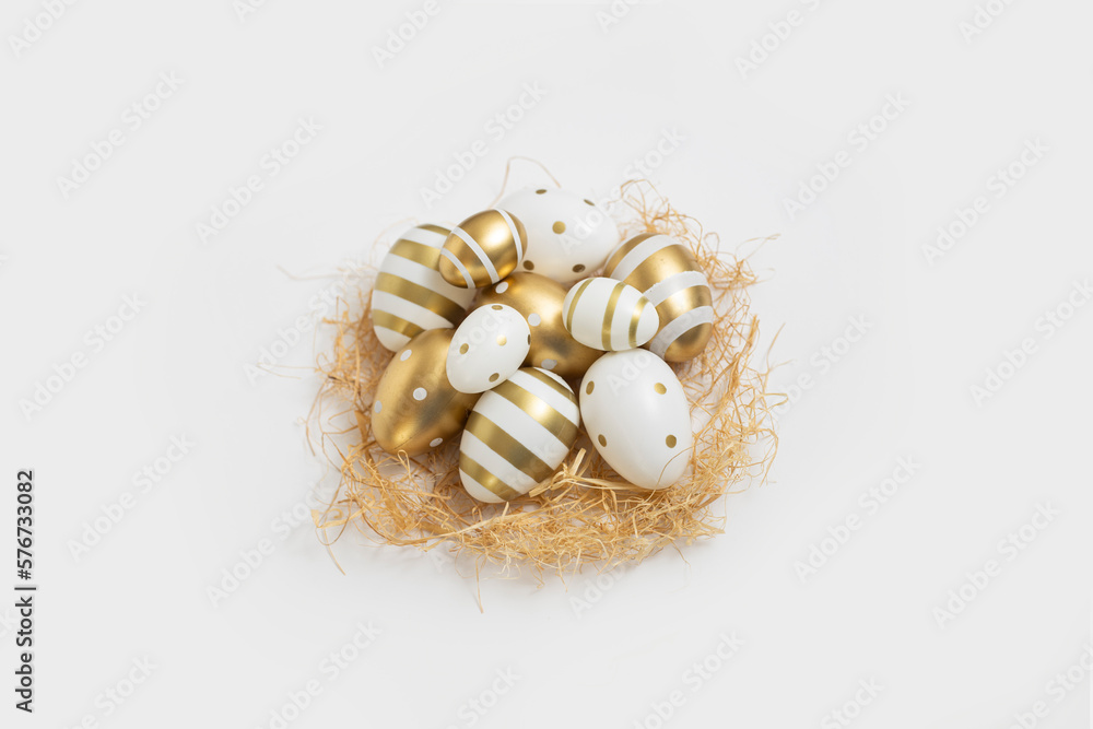 Obraz premium Decorative Easter eggs and straw on a white background