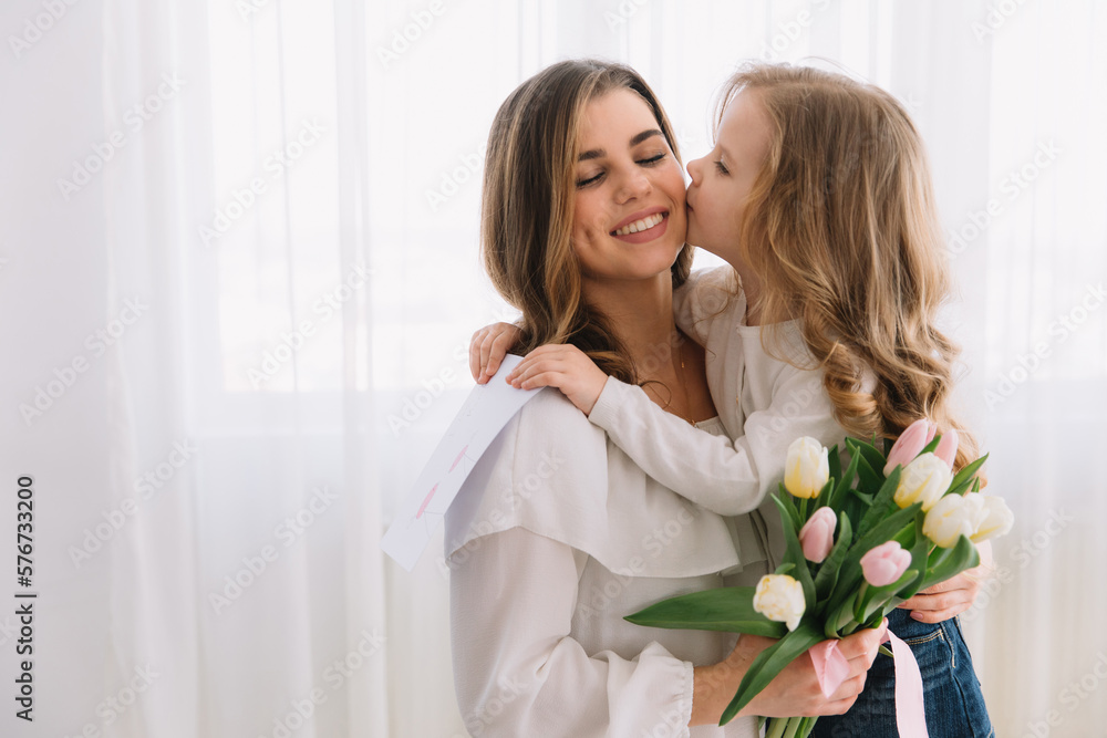 Happy mother's day. Child daughter congratulates moms and gives her a postcard and flowers tulips. Happy mother's day. Child daughter congratulates moms and gives her a postcard and flowers tulips.