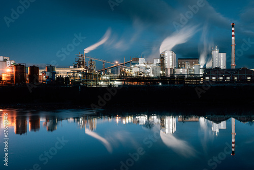 Chemical plant by river at twilight