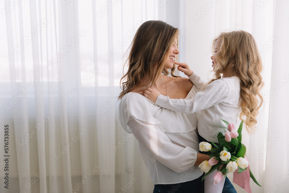 Happy mother's day. Child daughter congratulates moms and gives her flowers tulips. Happy mother's day. Child daughter congratulates moms and gives her flowers tulips.