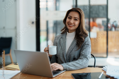 Portrait of a business woman talking on the phone and drinking coffee