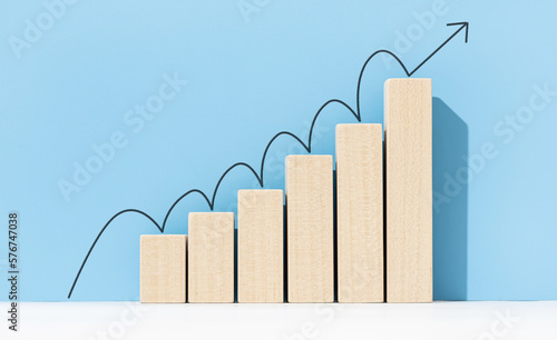 Growth, increasing business, success process concept. Increasing bar graph with arrow going up on blue background. Copy space