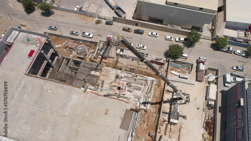 Dalton, Israel - 22 October 2020: Aerial view of operating cement machinery in a building under construction. Dalton, Israel - 22 October 2020: Aerial view of operating cement machinery in a building under construction.
