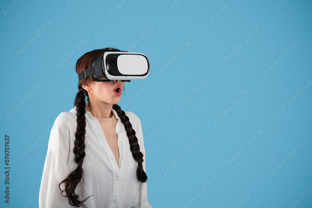 Glad surprised teen european girl student with pigtails in vr glasses look at copy space Glad surprised teen european girl student with pigtails in vr glasses look at copy space