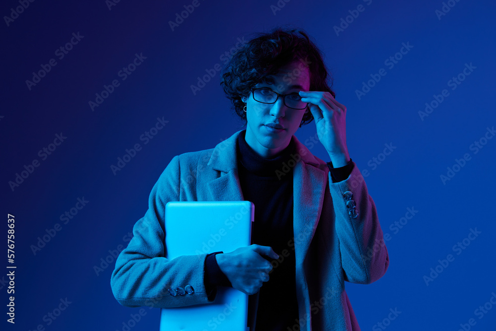Obraz premium man with a laptop in his hands and a jacket, smile, glasses in blue light, Blue Perennial color, cyber security, technology, laptop copy space, trend neon, freelancer, purple light