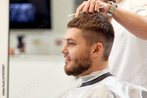 man visiting professional hairstylist in barber shop