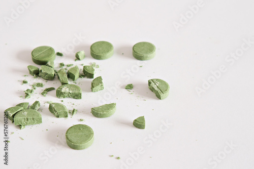 Fototapeta Naklejka Na Ścianę i Meble -  Green targets and crushed pills on a white background. . Concept of medicine. Close-up