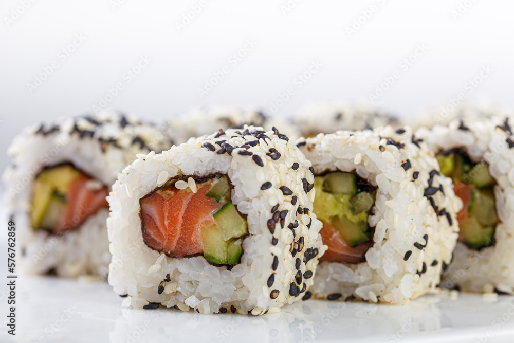 Sushi with salmon on a white plate with wasabi, ginger, soy, chopsticks on a white background Sushi with salmon on a white plate with wasabi, ginger, soy, chopsticks on a white background