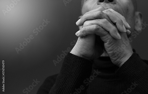 praying to god with hands together Caribbean man praying with black background stock photo