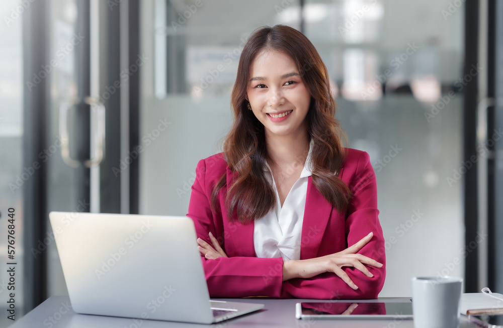 Beautiful asian businesswoman sitting crossed arms smiling looking at camera in office. Beautiful asian businesswoman sitting crossed arms smiling looking at camera in office.