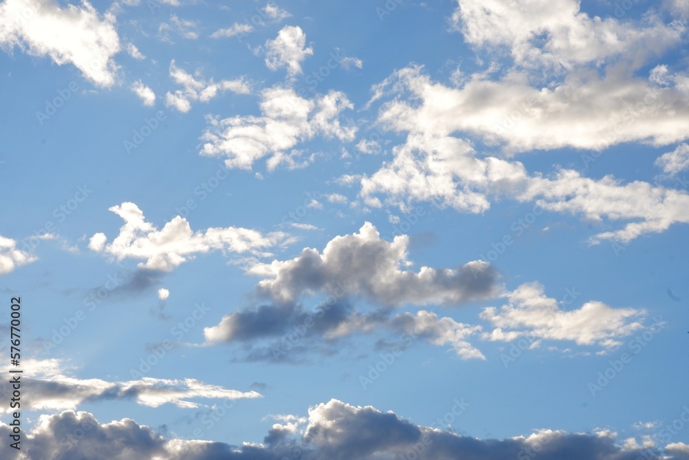 White fluffy clouds with blue sky and sun light for background texture White fluffy clouds with blue sky and sun light for background texture