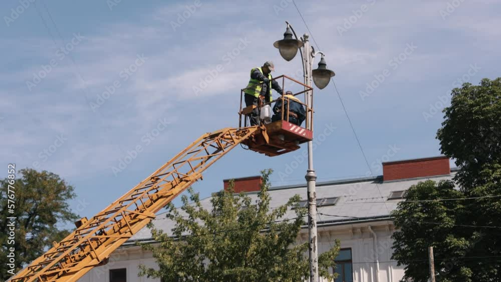 Video „repair street lamp, lift bucket, crane lifted. Worker is fixing