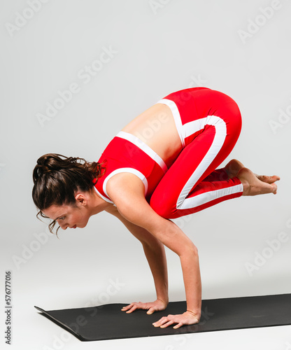 A beautiful woman is exercising in a yoga class for weight loss in the red sportwear
