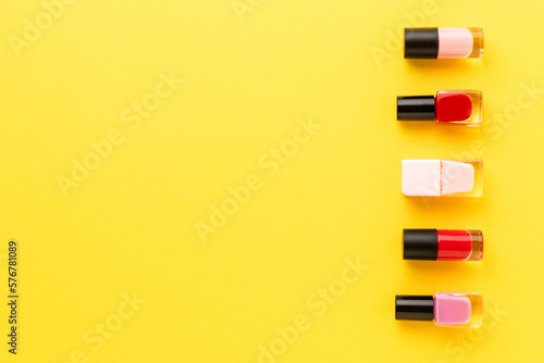 Nail polishes on yellow background. Beauty background