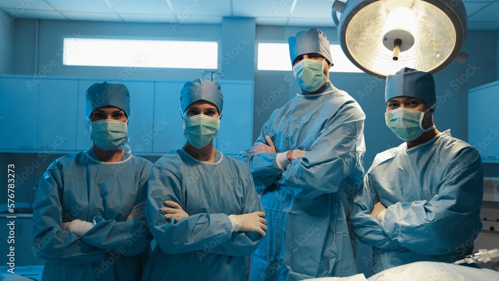 Portrait of The medical team standing and looking at camera in the operating room at the hospital. Successful surgery. Portrait of The medical team standing and looking at camera in the operating room at the hospital. Successful surgery.