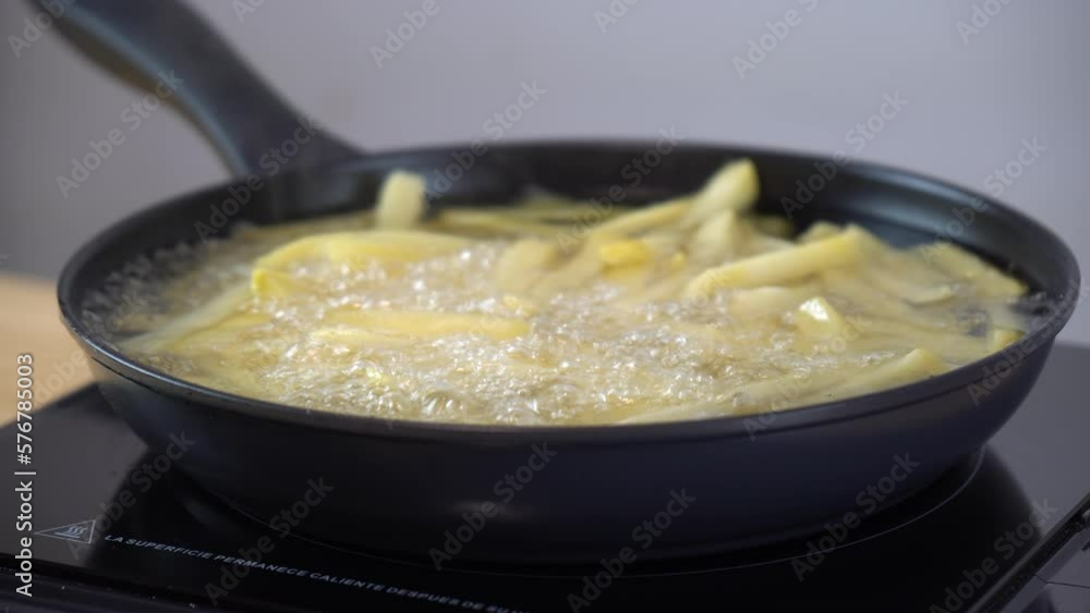 Fried fries on a black pan in the kitchen with hot oil Fried fries on a black pan in the kitchen with hot oil