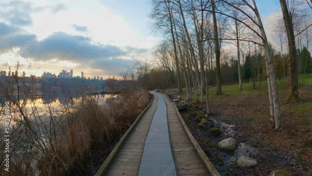 Trail by Peaceful Lake in the modern city, Deer Lake Park. Burnaby, Vancouver, BC, Canada. Colorful Winter Sunset Sky. Slow Motion Cinematic Pan. Trail by Peaceful Lake in the modern city, Deer Lake Park. Burnaby, Vancouver, BC, Canada. Colorful Winter Sunset Sky. Slow Motion Cinematic Pan.