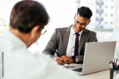 Business man having a discussion with his colleague in an office