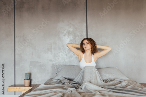 Young Woman stretching in bed after wake up