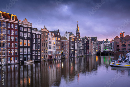 Evening panoramic view of the famous historic center with lights, bridges, canals and traditional Dutch houses in Amsterdam, Netherlands © Sen