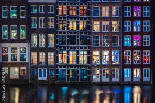 Colorful window of the traditional riverside houses at night in Amsterdam, Netherlands