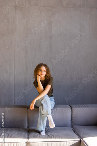 Happy young woman lying on couch and relaxing at home