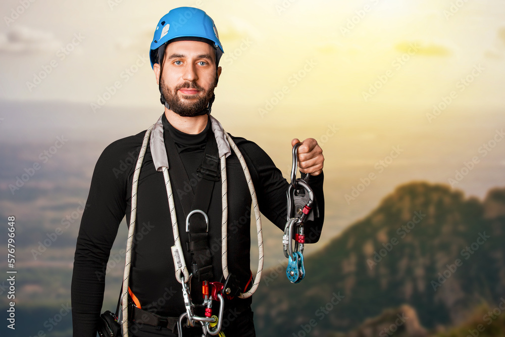 A man in a belay system for work at height. Carabiners, straps, safety ropes. mountain climbing A man in a belay system for work at height. Carabiners, straps, safety ropes. mountain climbing