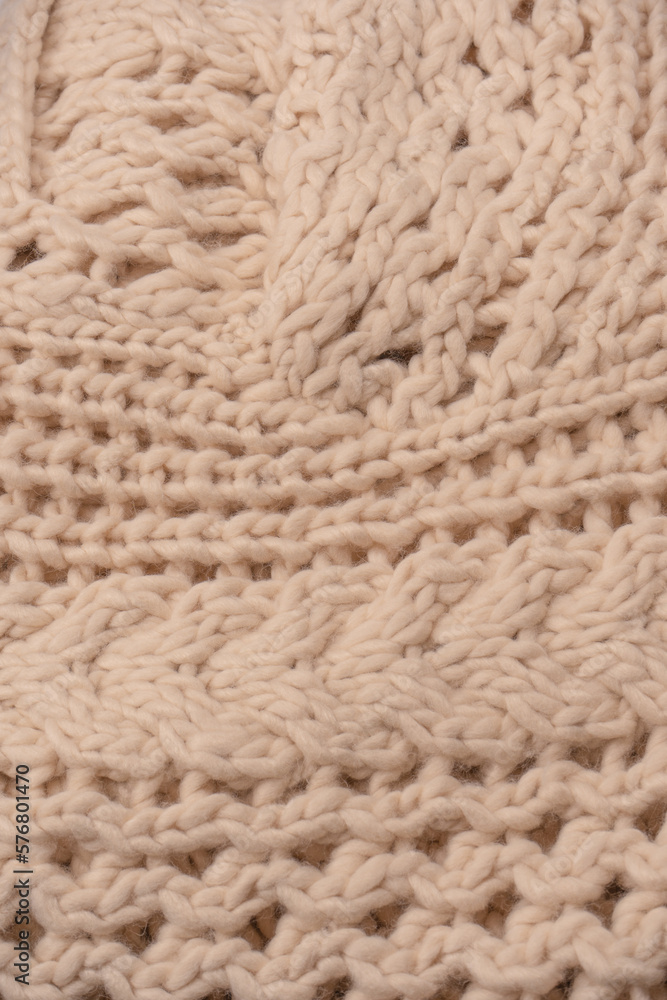 A fragment of beige knitted fabric, knitted from white sheep wool. A fragment of beige knitted fabric, knitted from white sheep wool.