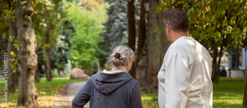 An elderly couple, man and woman walk in the autumn park.