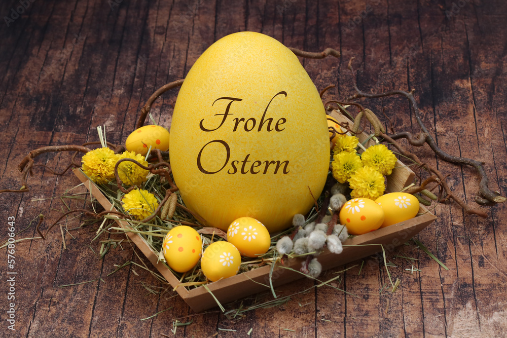 Grußkarte Frohe Ostern: Osternest mit gelben Ostereiern und einem beschrifteten Osterei. - obrazy, fototapety, plakaty 