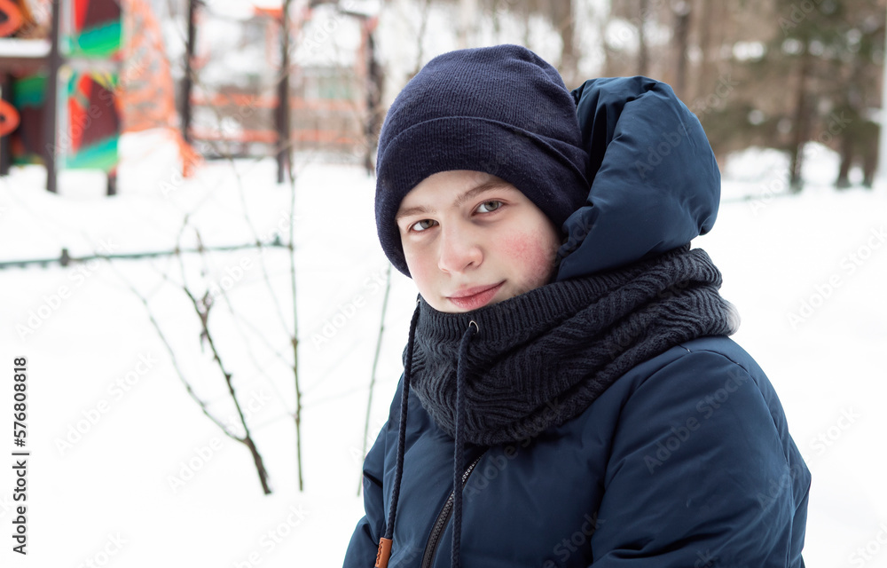 portrait of a teenager boy in winter in the park
