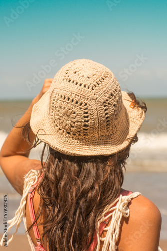 woman on the beach wearing crochet hat .Outfit spring summer