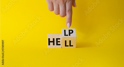 Help vs Hell symbol. Businessman hand points at turned wooden cubes with words Hell and Help. Beautiful yellow background. Psychology and Help vs Hell concept. Copy space