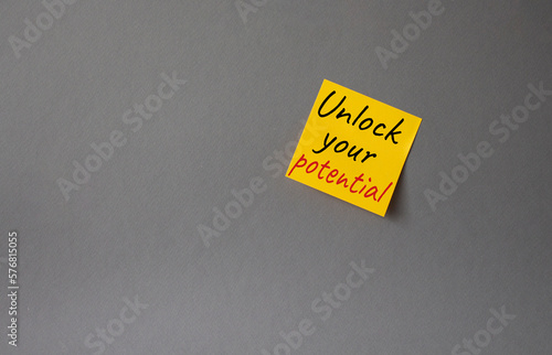 Unlock your Potential symbol. Concept words Unlock your Potential on orange steaky note. Beautiful grey background. Business and Unlock your Potential concept. Copy space. photo